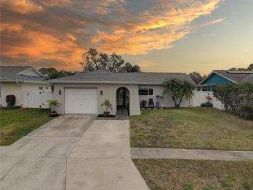 Beautiful updated home with a landscaped yard, driveway, and white garage door at 12391 70Th St, Largo, FL 33773