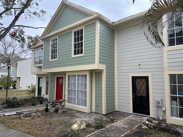 Exterior view of charming townhome with two-toned paint and landscaping at 13909 Fletchers Mill Dr, Tampa, FL 33613