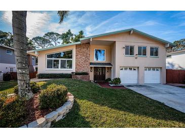 Two-story house with a brick facade, attached garage, and manicured lawn at 14311 83Rd Pl, Seminole, FL 33776