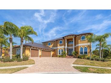 Beautiful two-story house with three-car garage and palm trees at 288 Mobbly Bay Dr, Oldsmar, FL 34677