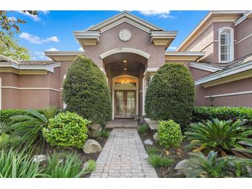 Inviting front entrance featuring a beautifully landscaped walkway and arched doorway at 2987 Wentworth Way, Tarpon Springs, FL 34688