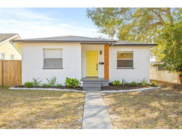 Charming bungalow with a yellow door, landscaping, and a walkway at 3034 Burlington N Ave, St Petersburg, FL 33713