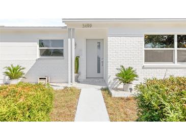 Charming home with a painted brick facade, well-kept landscaping, and a modern gray front door at 3499 43Rd N St, St Petersburg, FL 33713