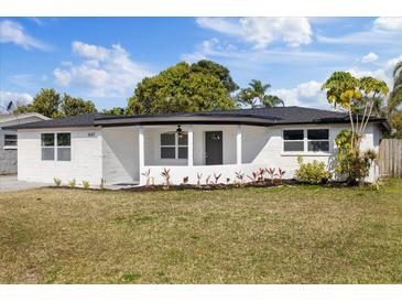 Newly renovated house featuring a modern facade and well-manicured lawn at 3547 Garfield Dr, Holiday, FL 34691