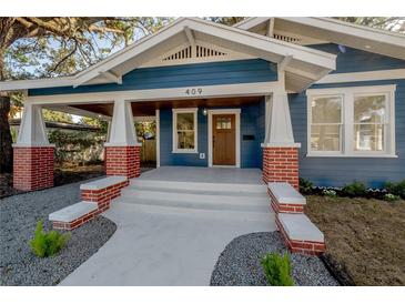 Charming craftsman home with blue siding, brick accents, and a covered porch at 409 E Adalee St, Tampa, FL 33603