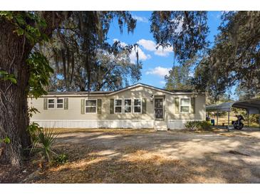 Tan single-wide mobile home with carport at 5104 Nesmith Rd, Plant City, FL 33567