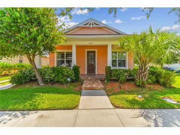 Charming one-story home with a peach-colored facade, front porch, and landscaped yard at 5200 Suncatcher Dr, Wesley Chapel, FL 33545