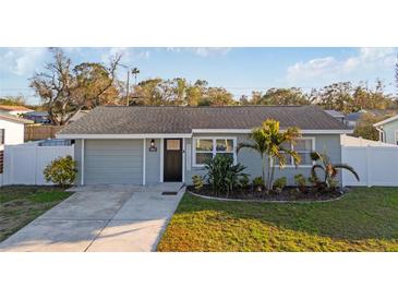 Charming single-story home with well-maintained landscaping, a garage, and a welcoming entrance at 5864 Mckee Lake N Dr, St Petersburg, FL 33709