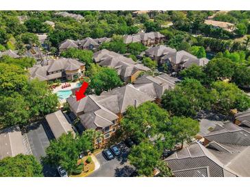 Aerial view of a community with a pool, showing a condo building and surrounding landscape at 2245 Chianti Pl # 718, Palm Harbor, FL 34683