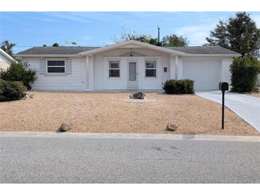 White single-story home with a landscaped yard and attached garage at 3556 Bradford Dr, Holiday, FL 34691