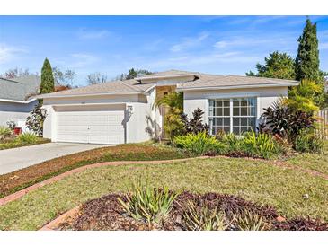 Single-story home with attached garage, landscaping, and a well-maintained lawn at 4251 Whittner Dr, Land O Lakes, FL 34639