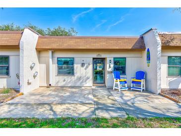 Inviting condo exterior featuring a patio, and blue chairs at 1505 Mission Hills Blvd # 4D, Clearwater, FL 33759