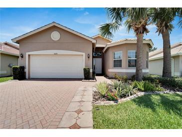 Single-story home with a two-car garage and landscaped front yard at 16028 Golden Lakes Dr, Wimauma, FL 33598