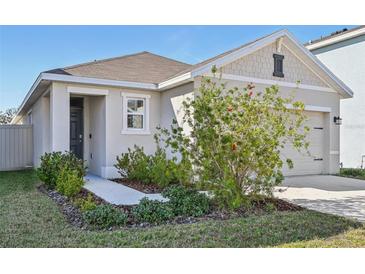 Inviting house exterior featuring a landscaped walkway and two-car garage at 16942 Trite Bend St, Wimauma, FL 33598