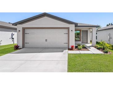 Modern house exterior with a two-car garage and well-manicured lawn at 29543 Fedora Cir, Brooksville, FL 34602