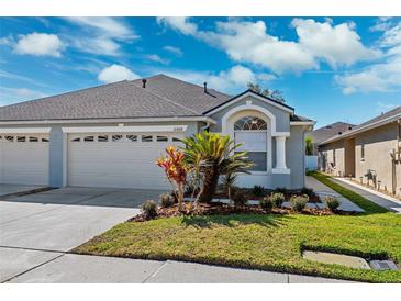 Charming single-story home featuring a two-car garage and inviting landscaped front yard at 31806 Larkenheath Dr, Wesley Chapel, FL 33543