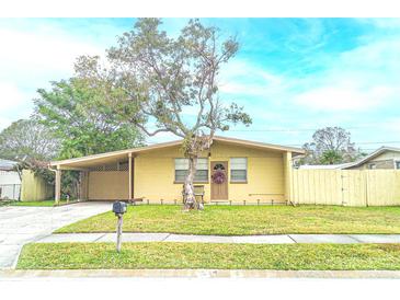 Cute yellow house with a carport and a fenced backyard at 4513 W Clifton St, Tampa, FL 33614