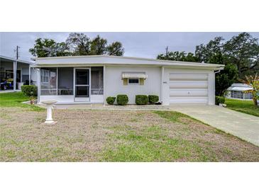 Single-wide manufactured home with carport and small lawn at 6125 Alpine Dr, Zephyrhills, FL 33542