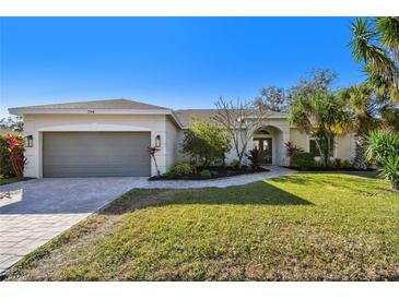 One-story home with gray garage door and well-manicured lawn at 714 Hidden Lake Dr, Tarpon Springs, FL 34689