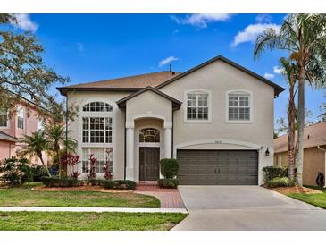 Two-story home with an attached two-car garage, arched windows, and a well-manicured front lawn at 8619 Foxtail Ct, Tampa, FL 33647