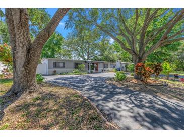 Charming single-story home with mature trees and beautifully landscaped front yard at 1201 77Th N St, St Petersburg, FL 33710