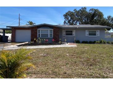 Ranch style home with brick facade, attached garage, and landscaped yard at 12361 114Th St, Largo, FL 33778