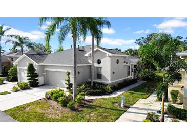 Gray two-story house with a two-car garage and lush landscaping at 1252 Lyndhurst Greens Dr, Sun City Center, FL 33573