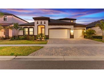 Beautiful single Gathering home with three-car garage and manicured lawn at twilight at 13182 Twin Bridges Dr, Riverview, FL 33579