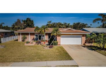 Single-story home with a two-car garage and well-manicured lawn at 14993 Imperial Point N Dr, Largo, FL 33774