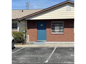 Charming condo with brick facade, blue door, and well-maintained landscaping at 24862 Us Highway 19 N # 1602, Clearwater, FL 33763