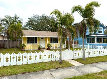 Cute yellow house with white picket fence and palm trees at 2526 44Th S St, St Petersburg, FL 33711