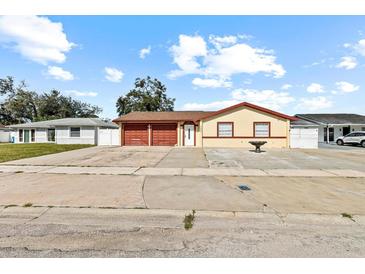 House exterior featuring a two-car garage and well-maintained landscaping at 7007 Lambright Ct, Tampa, FL 33634