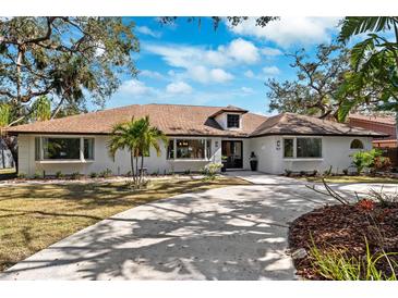 White single-story home with brown roof, landscaped yard, and circular driveway at 1621 Park N St, St Petersburg, FL 33710