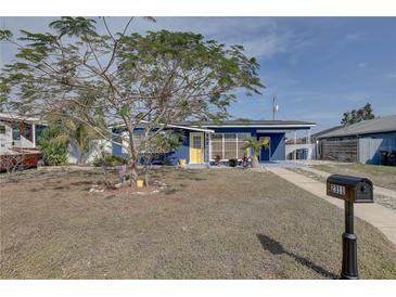 Charming blue house featuring a yellow door and a well-manicured front yard at 2311 Wellesley, Bradenton, FL 34207