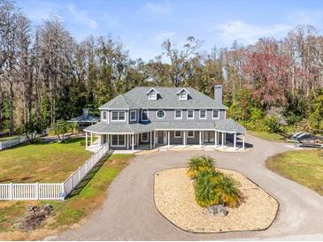 Two-story house with wrap-around porch, large backyard, and circular driveway at 3663 Berger Rd, Lutz, FL 33548