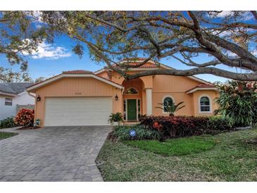 Attractive single-story home with a terracotta roof, landscaping, and a paved driveway at 5232 White Sand Ne Cir, St Petersburg, FL 33703