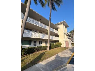 Building exterior showcasing mid-century architecture, landscaping, and ample parking at 1235 S Highland Ave # 3-303, Clearwater, FL 33756