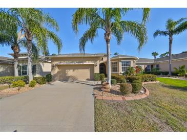 Tan one-story house with palm trees and landscaped yard at 335 Siena Vista Pl, Sun City Center, FL 33573