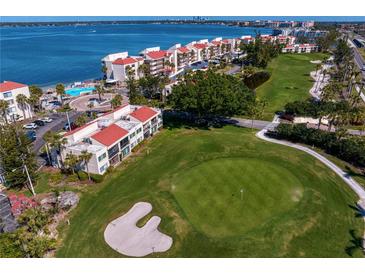 Stunning aerial view of property showcasing the golf course, waterfront, pool, and lush landscaping at 5633 Puerta Del Sol S Blvd # 306, St Petersburg, FL 33715