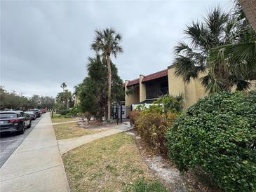 Exterior view of condo building with palm trees and parking at 107 S Obrien St # 220, Tampa, FL 33609