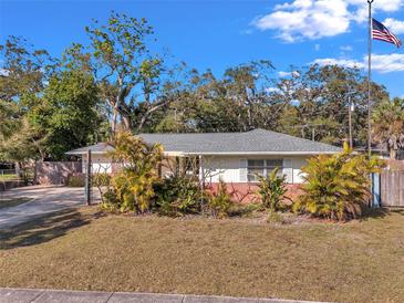 Charming single-story home featuring mature landscaping and a well-manicured lawn, complemented by a quaint design at 1276 Bermuda St, Clearwater, FL 33755
