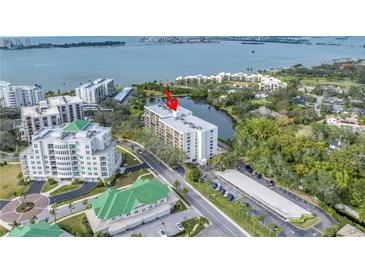 Stunning aerial view of the condo building with water views and lush landscaping at 220 Belleview Blvd # 108, Belleair, FL 33756