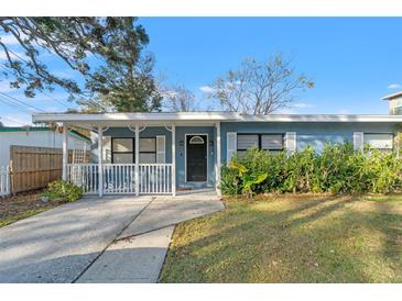 Charming light blue house with white trim, a covered porch, and a well-manicured lawn at 345 Dr Ml King Jr N St, Safety Harbor, FL 34695