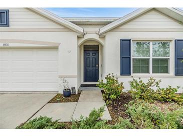 Front entrance with navy blue door and white trim at 11976 Brighton Knoll Loop, Riverview, FL 33579