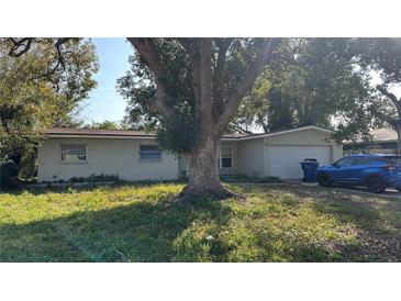 Charming single-story home featuring a large, mature shade tree in the front yard at 13634 Twig Ter, Largo, FL 33774