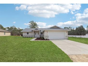 Charming single-Gathering home featuring a well-manicured lawn and a two-car garage at 15422 Wine Dr, Weeki Wachee, FL 34614