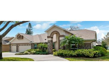 Charming single-story home boasts lush landscaping, an arched entryway, and a two-car garage at 16908 Equestrian Trl, Odessa, FL 33556