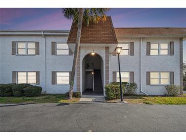 Charming two-story condo building with a well-maintained lawn and front entrance at 205 S Mcmullen Booth Rd # 202, Clearwater, FL 33759