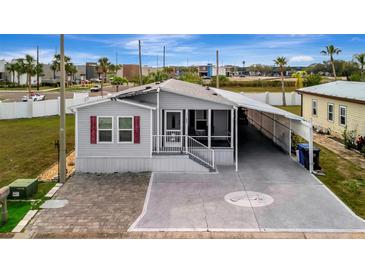 Charming single-story home with a screened porch, carport, and brick-paver driveway at 206 S Port Royal Ln, Apollo Beach, FL 33572