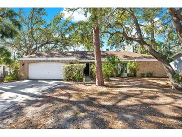 Brick house with attached garage, driveway, and mature trees in the front yard at 4346 Marine Pkwy, New Port Richey, FL 34652